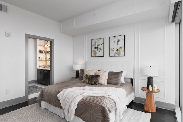 bedroom featuring wood-type flooring and ensuite bath