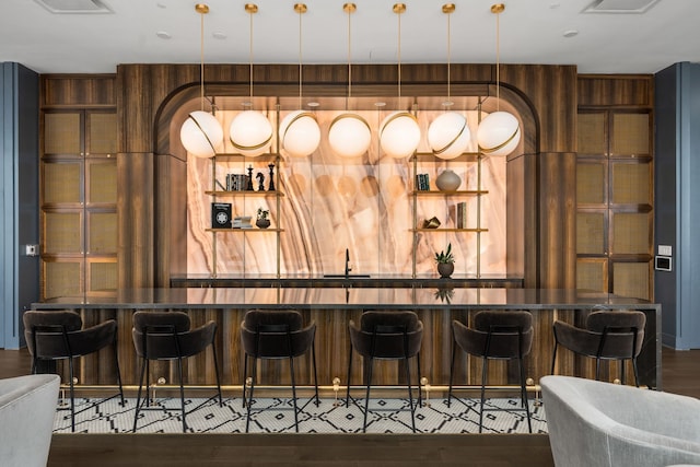 bar with wood-type flooring and sink