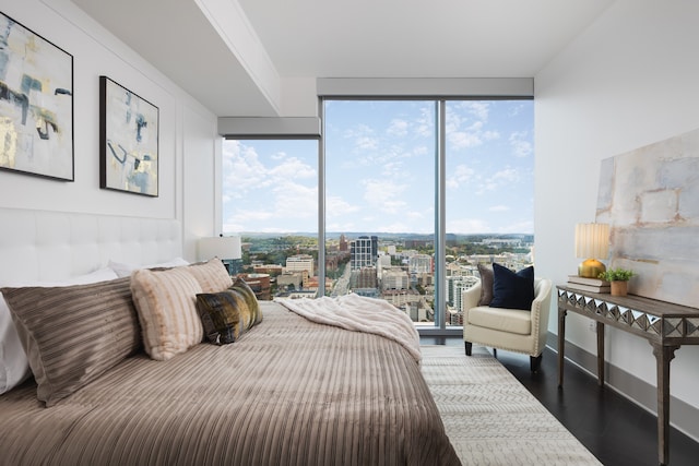 bedroom with floor to ceiling windows and dark hardwood / wood-style flooring