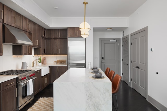 kitchen with pendant lighting, dark brown cabinets, and high quality appliances