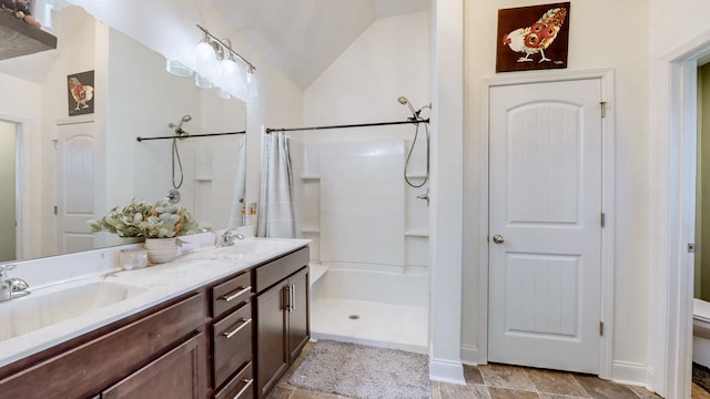 bathroom featuring walk in shower, lofted ceiling, vanity, and toilet