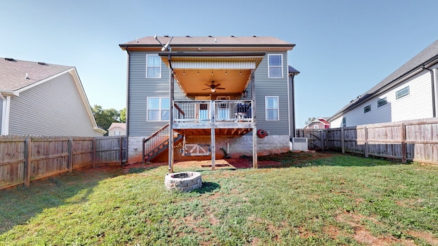 rear view of house with a lawn and ceiling fan