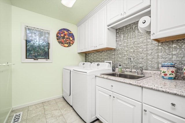 clothes washing area featuring cabinets, independent washer and dryer, and sink