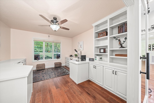 kitchen featuring a textured ceiling, dark wood-type flooring, white cabinetry, kitchen peninsula, and ceiling fan