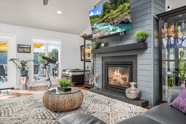 living room with hardwood / wood-style flooring, lofted ceiling, and a textured ceiling