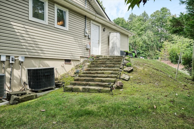 exterior space with a lawn and central AC