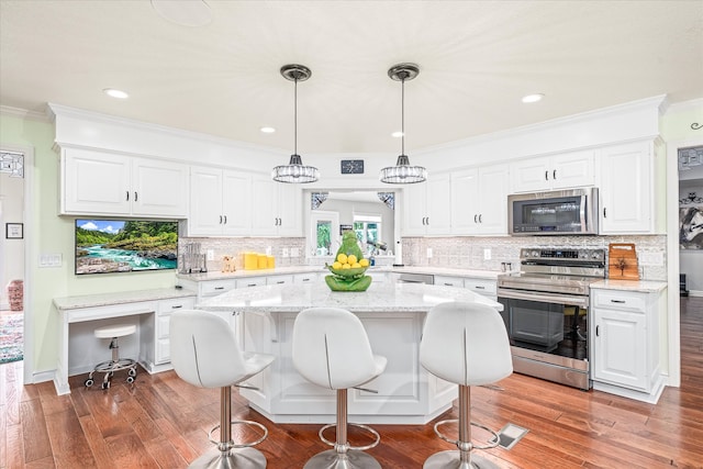 kitchen with appliances with stainless steel finishes, ornamental molding, white cabinetry, and dark hardwood / wood-style flooring