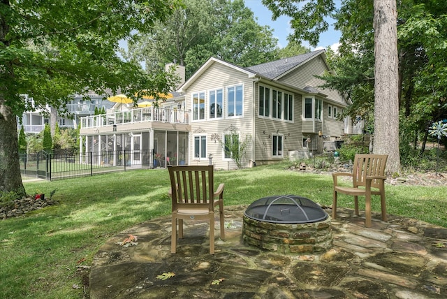 back of property featuring a yard, a patio, and an outdoor fire pit