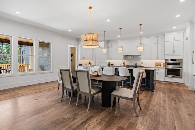 dining area featuring ornamental molding and hardwood / wood-style flooring