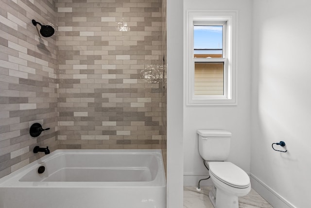 bathroom featuring tiled shower / bath combo and toilet