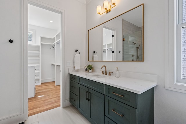 bathroom featuring walk in shower, vanity, and hardwood / wood-style flooring