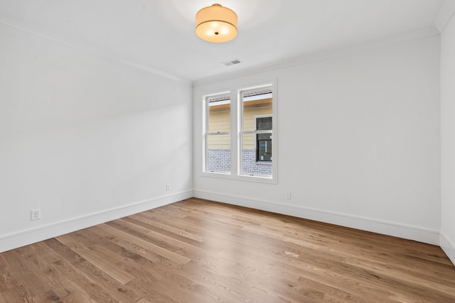 spare room featuring ornamental molding and wood-type flooring