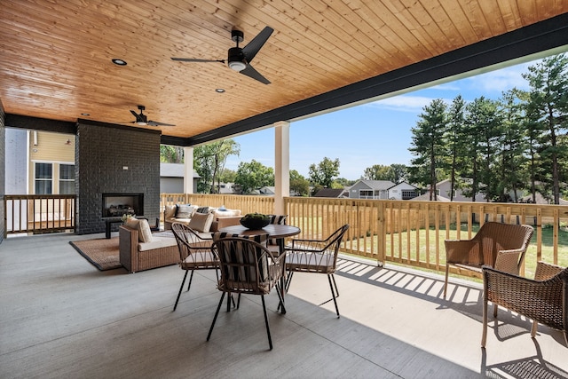 view of patio with an outdoor brick fireplace and ceiling fan