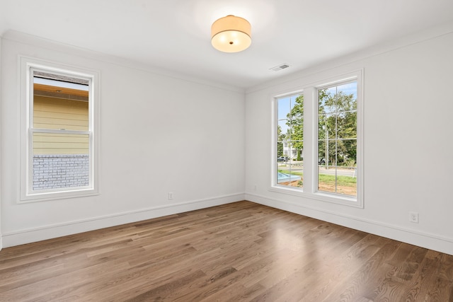 unfurnished room with ornamental molding and light hardwood / wood-style floors