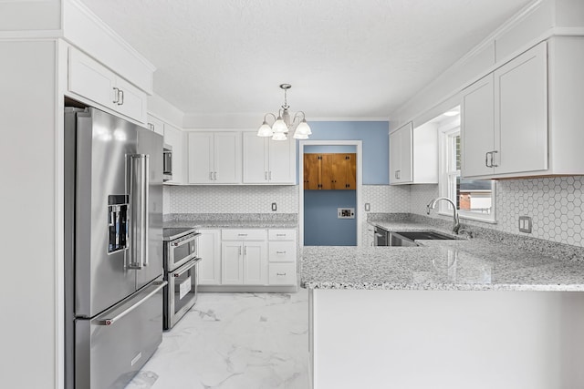 kitchen with white cabinetry, light stone counters, kitchen peninsula, pendant lighting, and stainless steel appliances