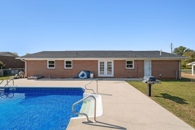 view of pool with a yard, french doors, and a patio area