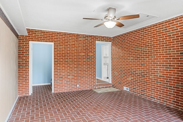 unfurnished room featuring a textured ceiling, crown molding, ceiling fan, and brick wall