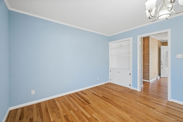 unfurnished bedroom with an inviting chandelier, crown molding, and light hardwood / wood-style floors