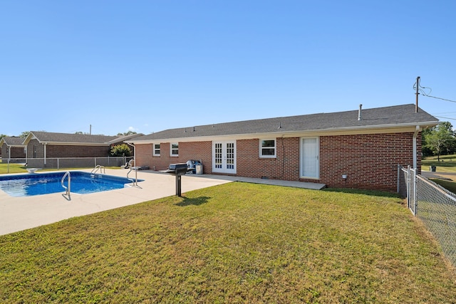 view of pool featuring a lawn, french doors, and a patio area