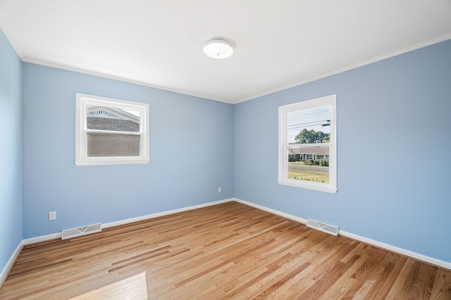 empty room with light wood-type flooring and ornamental molding