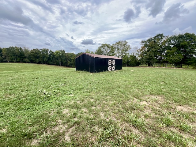 view of yard with an outbuilding and a rural view