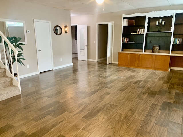 unfurnished living room with wood-type flooring and ceiling fan