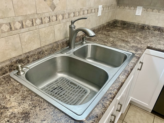 room details with white cabinets, light tile patterned flooring, and sink