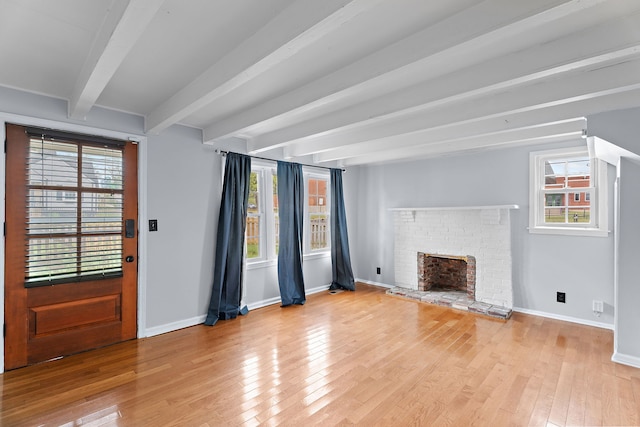 unfurnished living room featuring beamed ceiling, light hardwood / wood-style flooring, and a fireplace