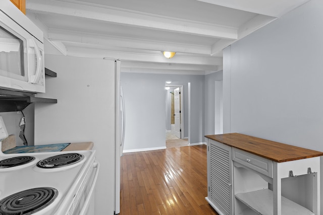 kitchen featuring white appliances, light hardwood / wood-style floors, and beamed ceiling