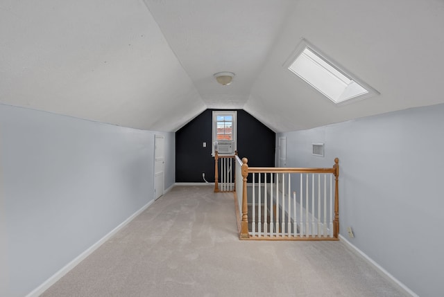 bonus room with vaulted ceiling with skylight, cooling unit, and light colored carpet