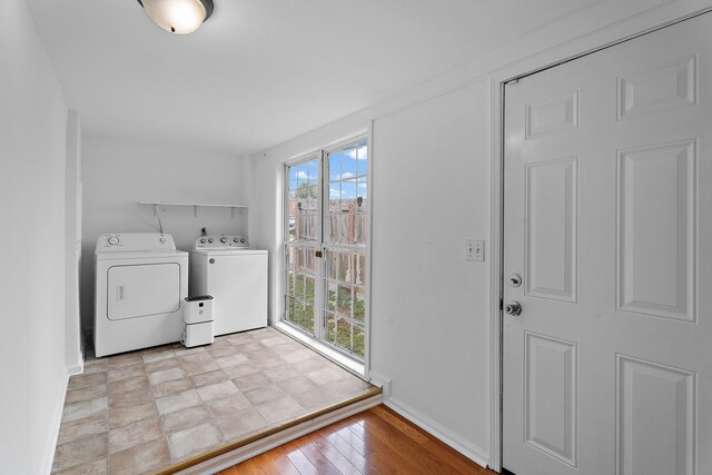 clothes washing area featuring washer and clothes dryer, plenty of natural light, and light hardwood / wood-style floors