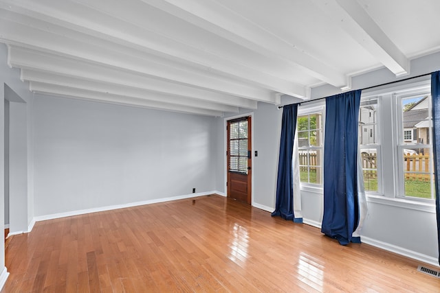 empty room featuring beam ceiling and hardwood / wood-style flooring