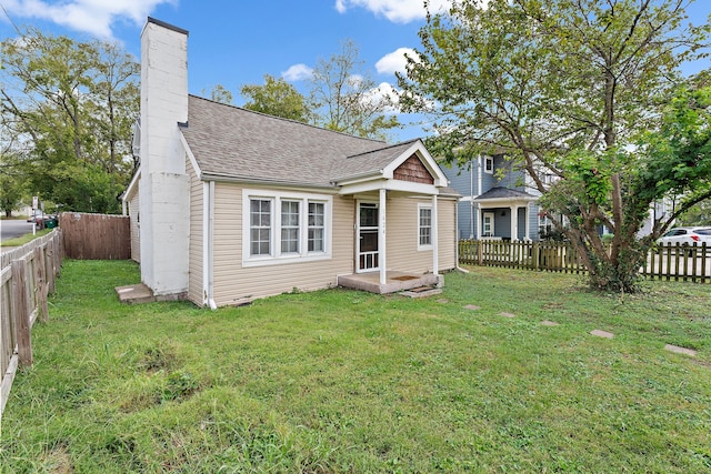 rear view of property featuring a yard