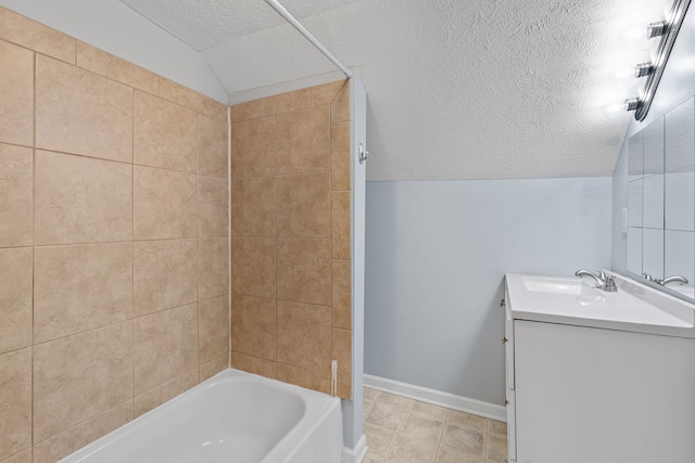 bathroom with a textured ceiling, tiled shower / bath combo, lofted ceiling, and vanity