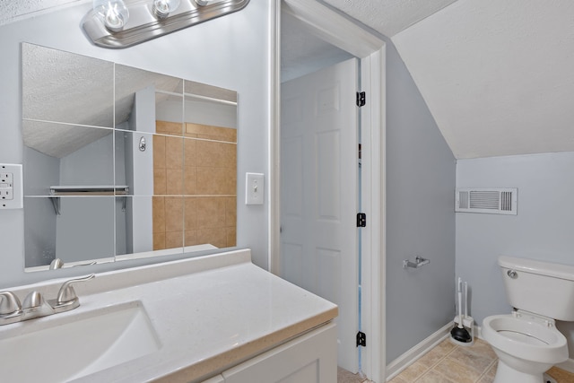 bathroom with tile patterned flooring, vaulted ceiling, vanity, and toilet