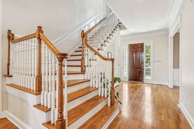 foyer entrance featuring wood-type flooring and crown molding