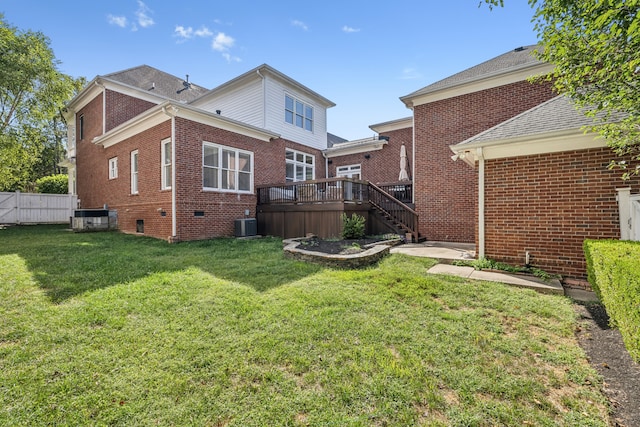 rear view of property with central AC, a deck, and a yard