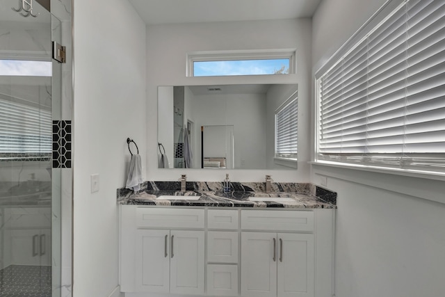 bathroom with a shower with door and vanity