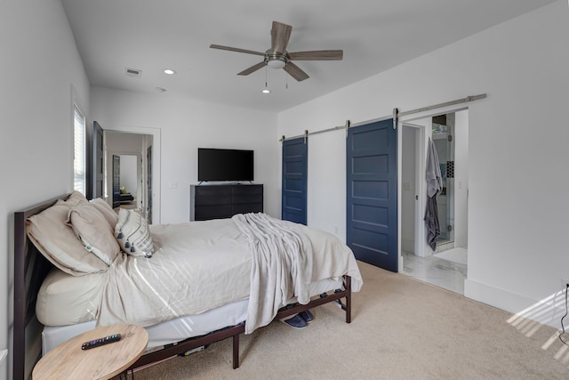 carpeted bedroom featuring ceiling fan and a barn door