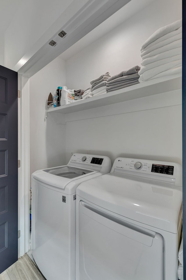 laundry room featuring wood-type flooring and independent washer and dryer