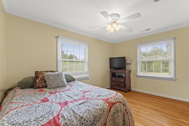 bedroom featuring ornamental molding, light hardwood / wood-style floors, and ceiling fan