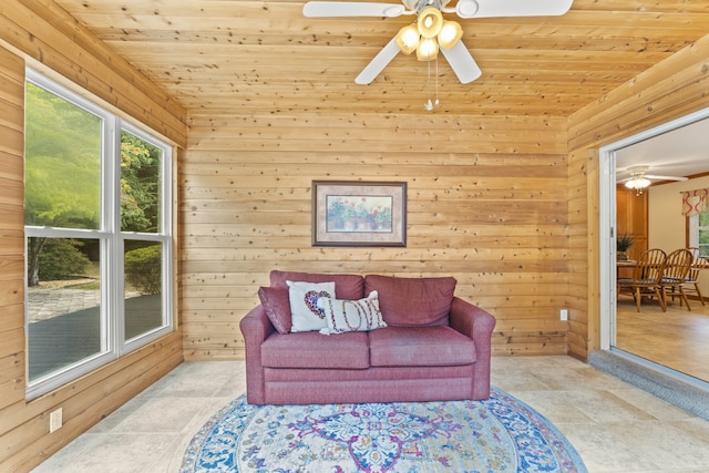 living room with ceiling fan, wooden walls, and wood ceiling