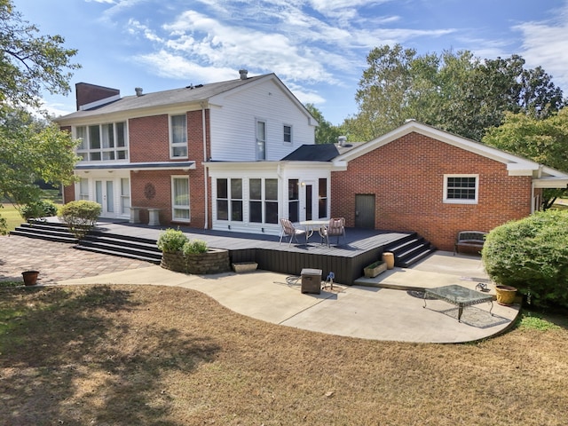 back of property featuring a deck and a patio area