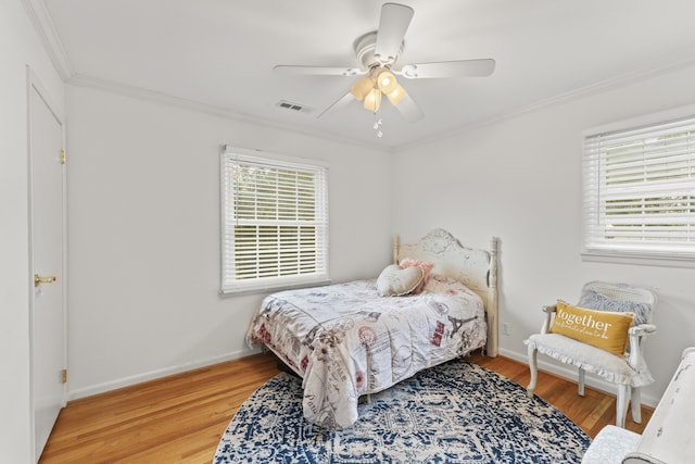 bedroom featuring ornamental molding, wood-type flooring, and ceiling fan