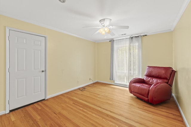 living area with ornamental molding, light wood-type flooring, and ceiling fan