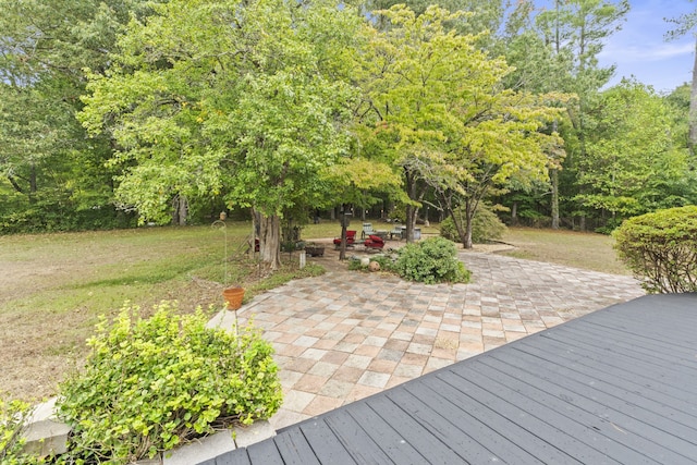 wooden terrace with a lawn and a patio area