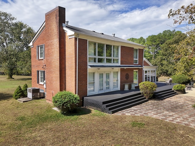 back of property with french doors, a deck, a yard, and central air condition unit