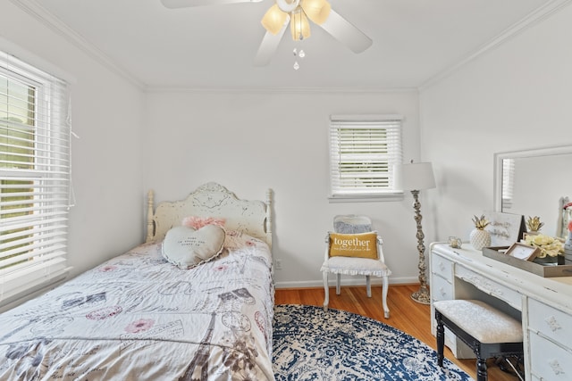 bedroom with ceiling fan, hardwood / wood-style flooring, ornamental molding, and multiple windows