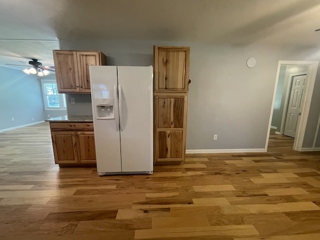 kitchen featuring white fridge with ice dispenser, light hardwood / wood-style flooring, and ceiling fan