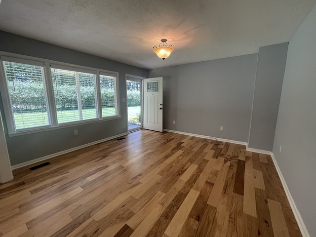 unfurnished room featuring a textured ceiling and wood-type flooring